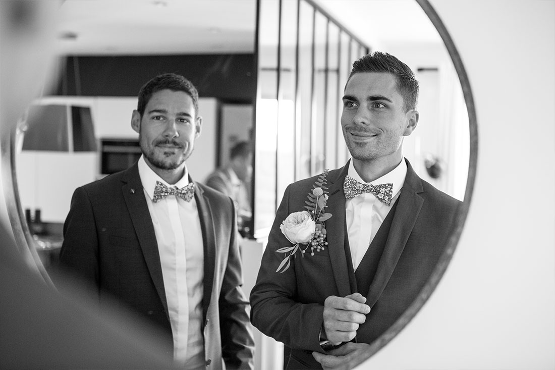 Le marié regarde son témoin dans le miroir